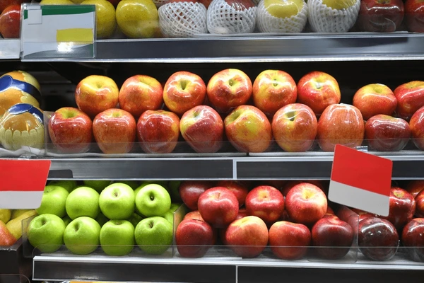 Fresh red and green apples displayed at Kenyan wholesale market showing various varieties with price tags in Kenyan shillings per kilogram